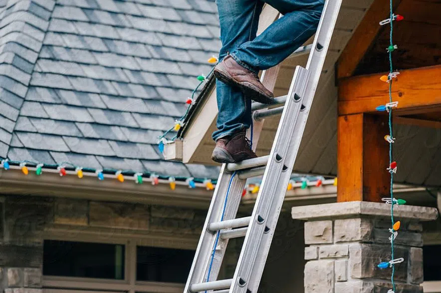 Чоловік розкладає різдвяні вогні.